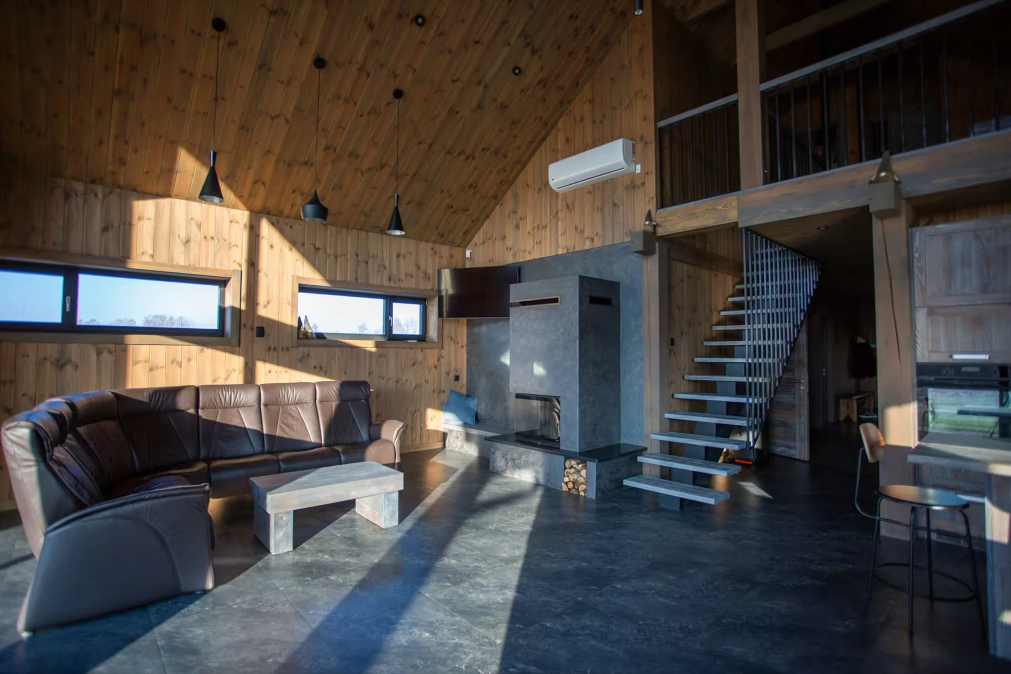 The retreat house’s spacious timber living room with a fireplace.
